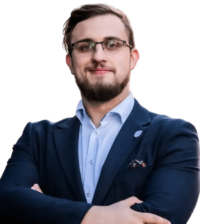 Mężczyzna z brodą w okularach, w niebieskiej koszuli i marynarce – specjalista cyberbezpieczeństwa